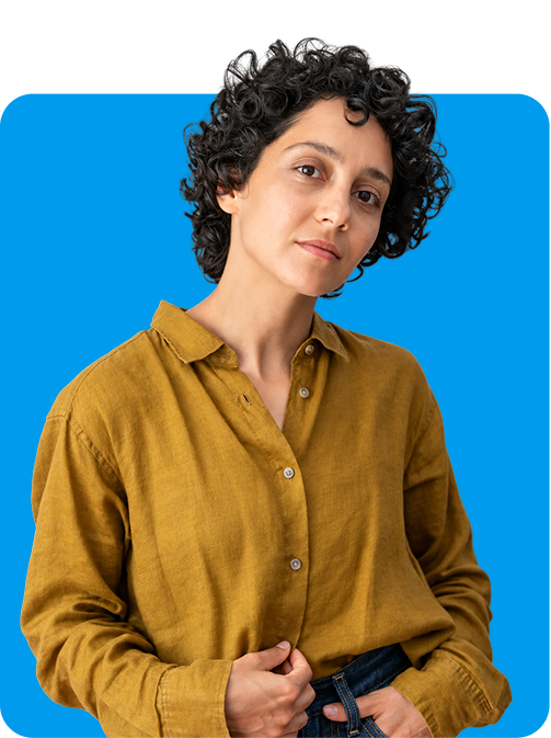 A person in a mustard shirt against The Wheel’s bright blue background